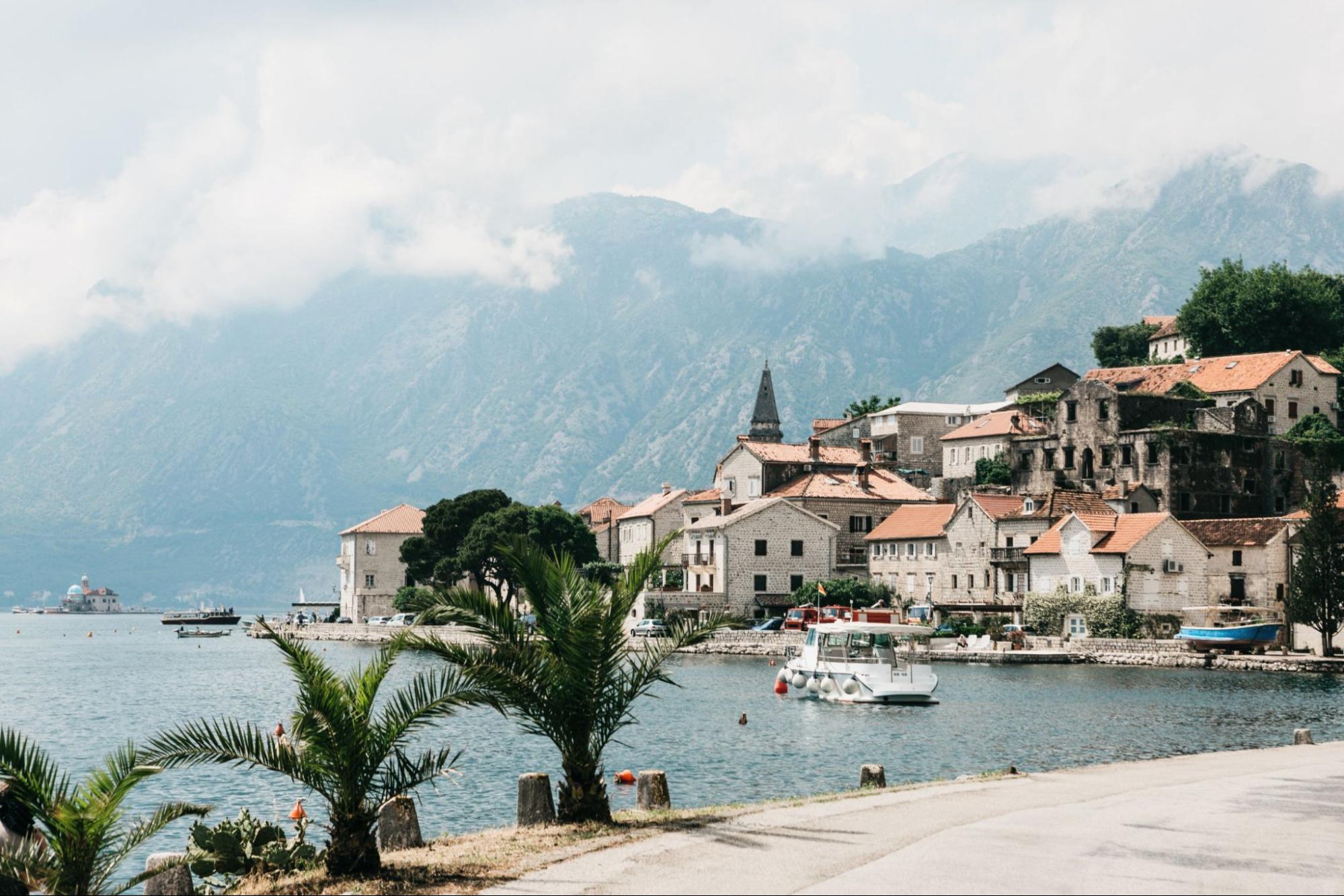 Beautiful view of the old coastal town of Perast in Montenegro with beautiful architecture, the sea and boats on the background of the mountains.