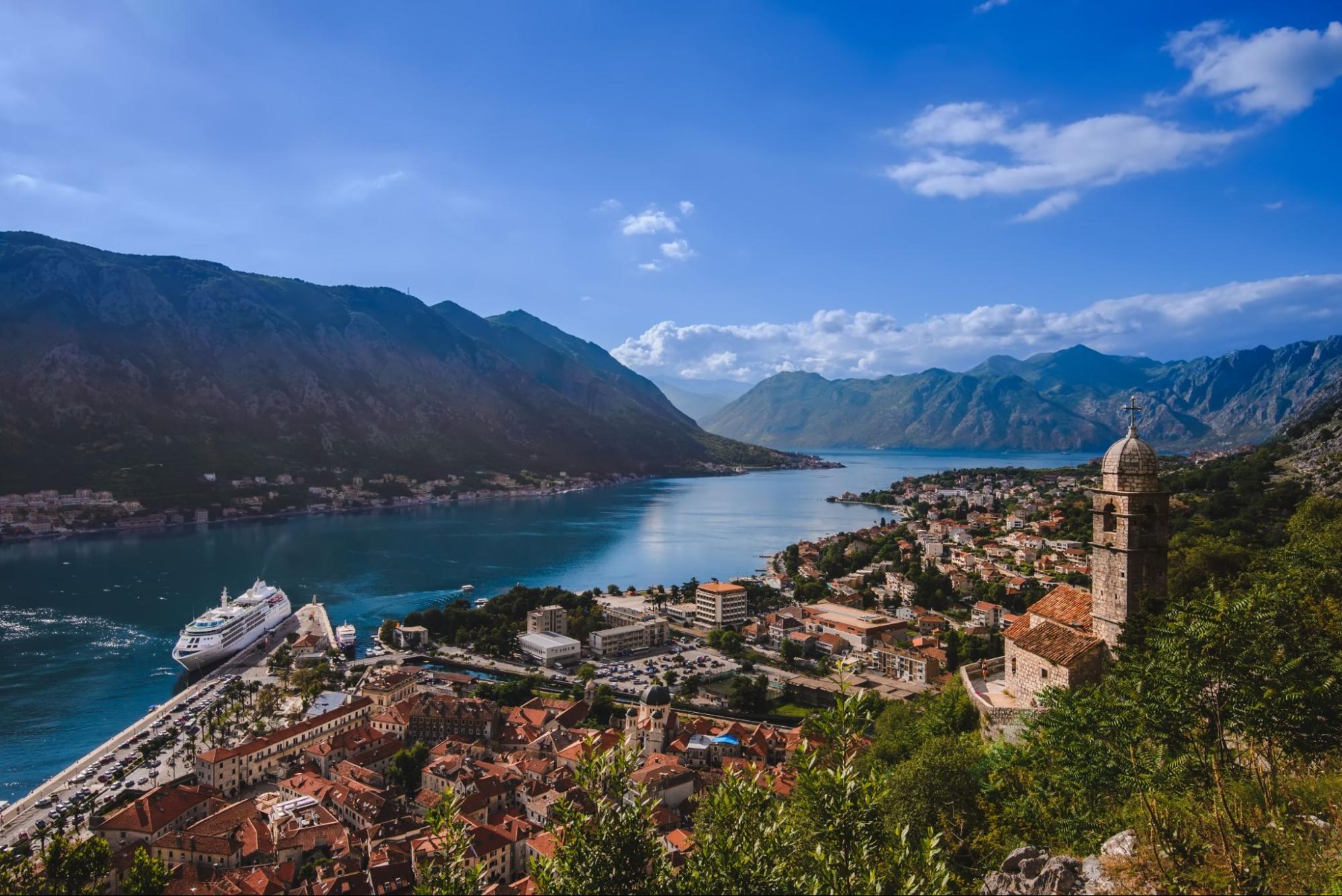 Kotor Bay and Old Town view from above Kotors castle of San Giovanni. Stone staircase, traditional house roofs, cathedral dome and Boka Kotorska wide angle view.